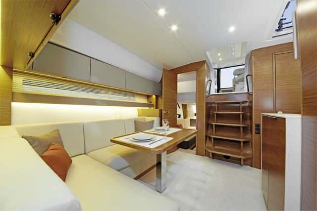 El espacio principal de la cabina respeta unas dimensiones adecuadas para este crucero. La dinete se complementa con un mueble suplementario y un asiento individual. 